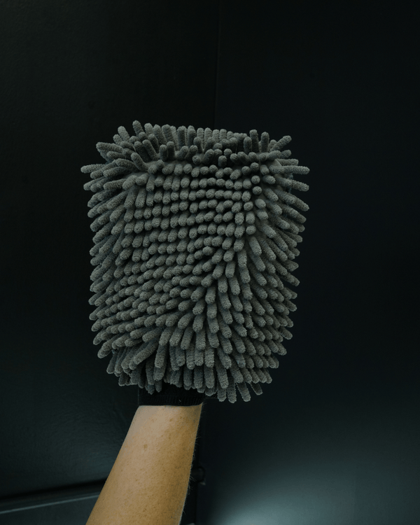 A detailer holding a noodle sponge on a black background