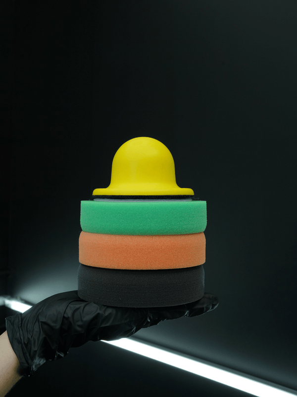 Stack of colourful foam blocks held by a gloved hand against a dark background