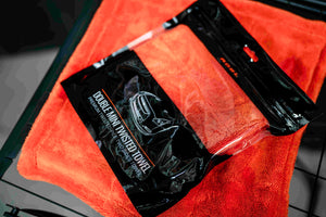 ADBL Double Mini Twisted Towel in opened doypack on large orange microfiber towel