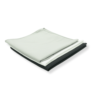 Folded black, white and grey suede cloths on a white background