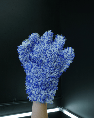 A person wearing a two tone 5 finger wash mitt on a black background