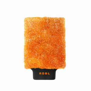 A orange car wash mitt with a black band on a white background