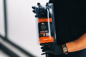 Person in black gloves holding ADBL Wheel Sword long wheel brush in its retail packaging