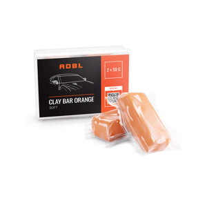 A box of orange soft clay bars with a black label