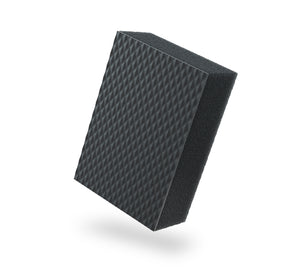 A black textured clay sponge on a white background