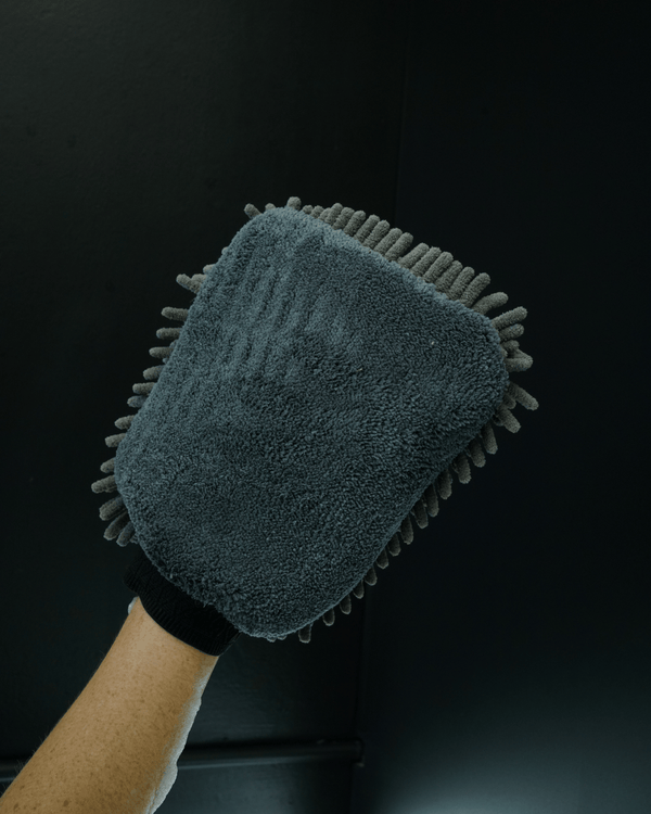A detailer holding a noodle sponge on a black background