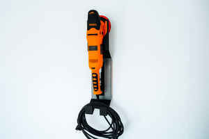 Front view of ADBL HANG IT HIGH polisher hanger with orange machine and wrapped power cord