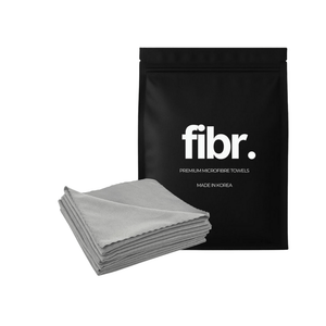 A black bag with FIBR written on it next to a stack of korean suede microfibre cloths