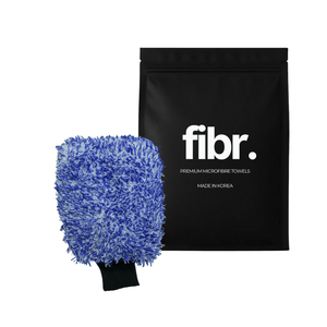 A black bag with FIBR written on it next to a microfibre car wash mitt