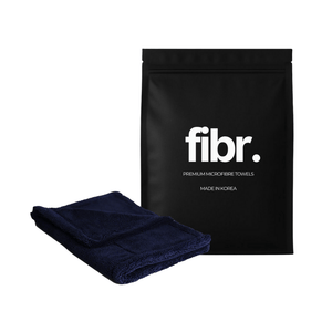 A black bag with FIBR written on it next to a dark blue mini car drying towel