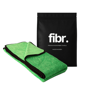 A black bag with FIBR written on it next to a green microfibre car drying towel