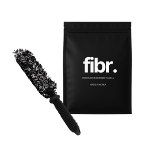 A black bag with FIBR written on it next to a black and white korean wheel woolie