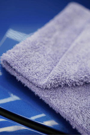 Folded purple microfibre cloth on a blue car