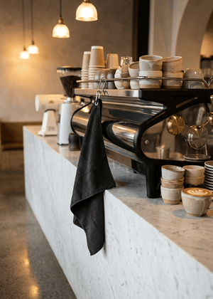 A luxury high end cafe with a barista cloth clipped onto a coffee machine