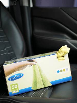 Box of Wipe Force cloths with a yellow cloth on a car seat