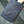 Grey microfibre towel held by a hand on a reflective surface